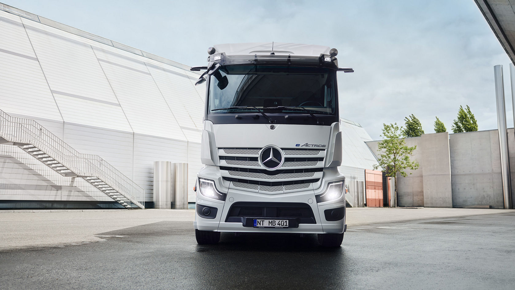 A diagram that shows different configurations of the eActros. It is divided into several sections, each of which describes a specific characteristic of the lorry: Cab: Optimised Living Space: Shows an image of a white eActros lorry from the front, standing in a paved square. Written below is: “Classic | StreamSpace, L-cab, 2.3 m”. Maximised Living Space: Shows a similar image of a white eActros lorry, also from the front, in a paved square. Written below is: “ProCabin, Stream/Big/GigaSpace, L-cab, 2.3 m”. LFP batteries: There are two subcategories for both cab options: “eActros 400” and “eActros 600”. The eActros 400: has “2 battery packs (414 kWh)”. The eActros 600: has “3 battery packs (621 kWh)”. Charging: The charging options for all four eActros models (eActros 400 and 600 for both cabs) are listed: “CCS 2 charging (up to 400kW)” "No MCS charging" (for eActros 400 and eActros 600 with Optimised Living Space) “MCS charging (up to 1000 kWh)” (for eActros 600 with Maximised Living Space only) Payload: For eActros 400 (both cabs): “~25t” For eActros 600 (both cabs): “~22t” Some of the fields have a blue “NEW” tag indicating new or updated features.