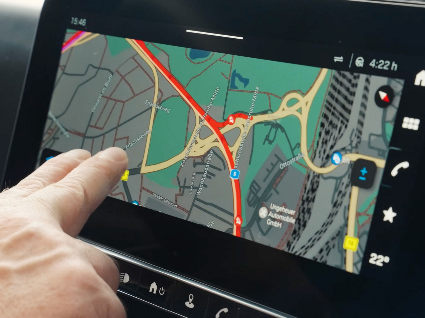 A finger taps on the navigation screen in the eActros from Mercedes-Benz Trucks, which shows a detailed road map with marked routes and locations. The map is displayed in different colours to show roads, green areas and water.