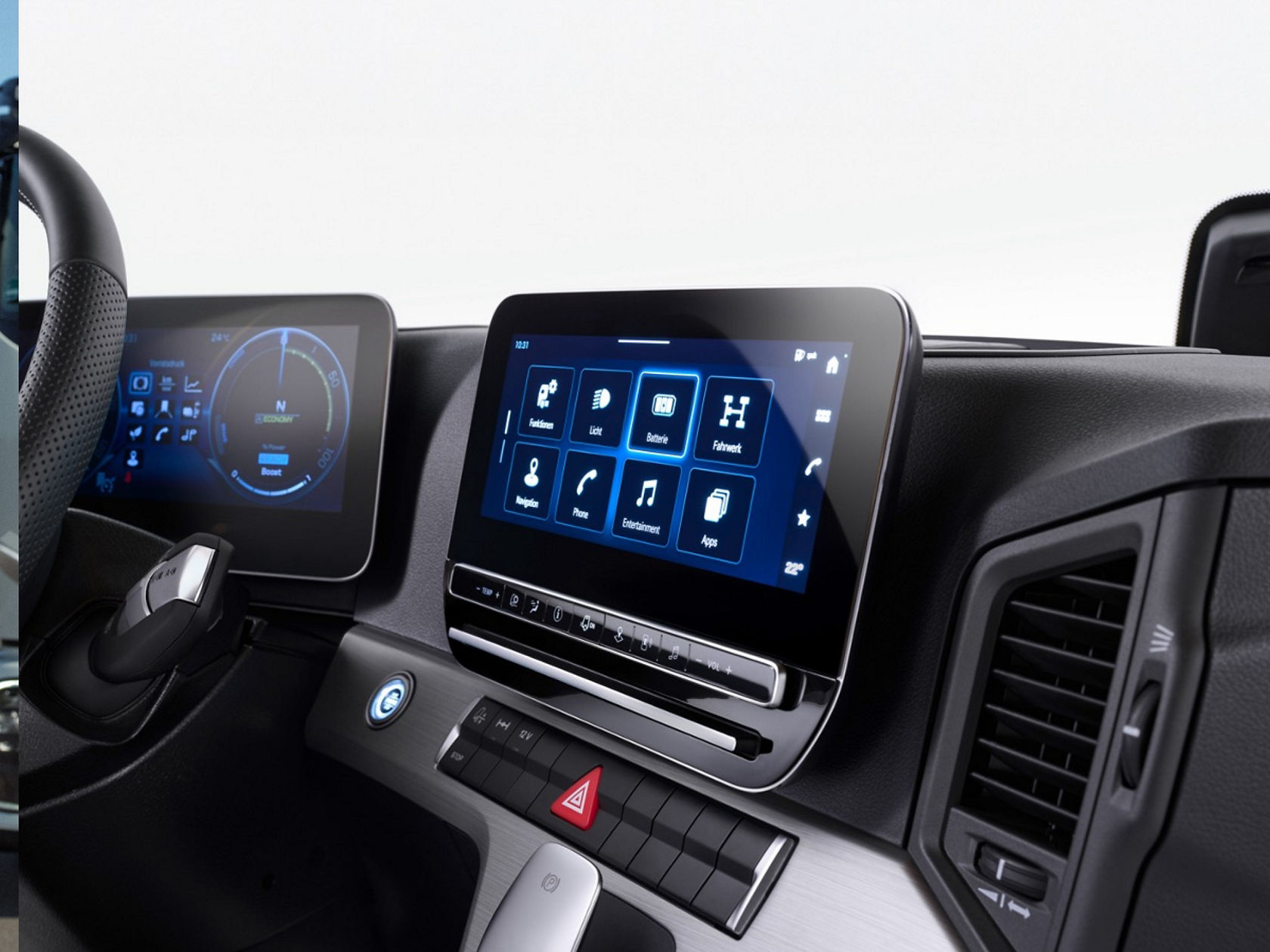 The image shows the digital cockpit of the eActros from Mercedes-Benz Trucks with two screens. The left screen shows driving information and the right screen displays a menu with various functions such as navigation, telephone and entertainment.