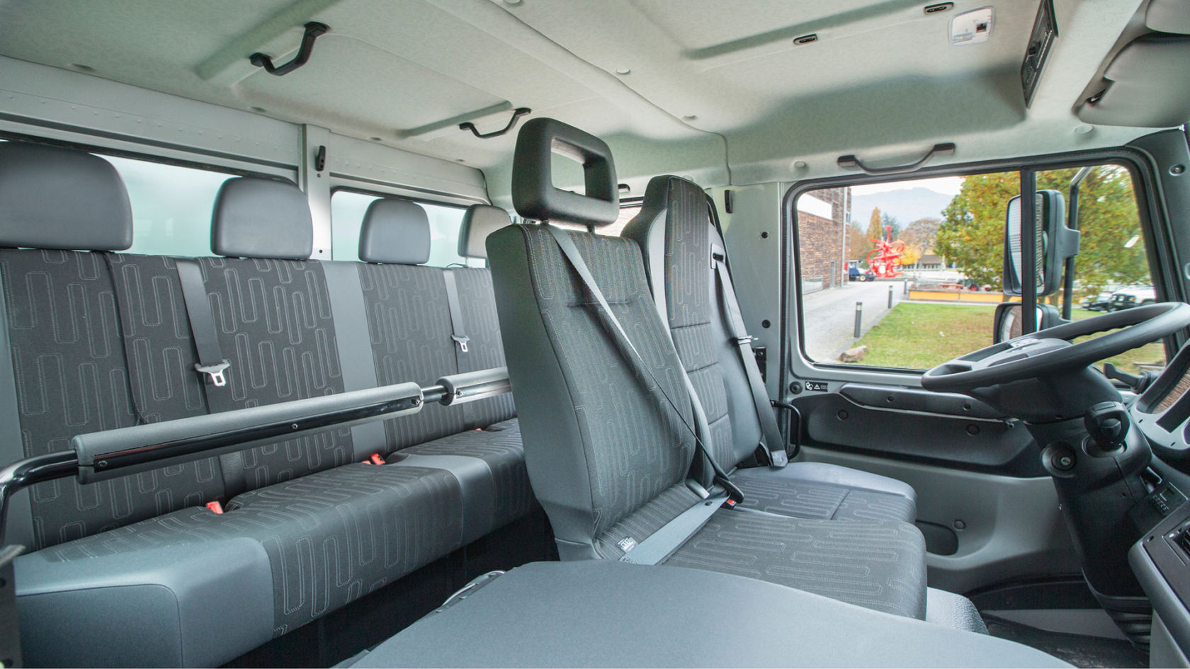 The interior of a Unimog with multiple seats and seat belts.
