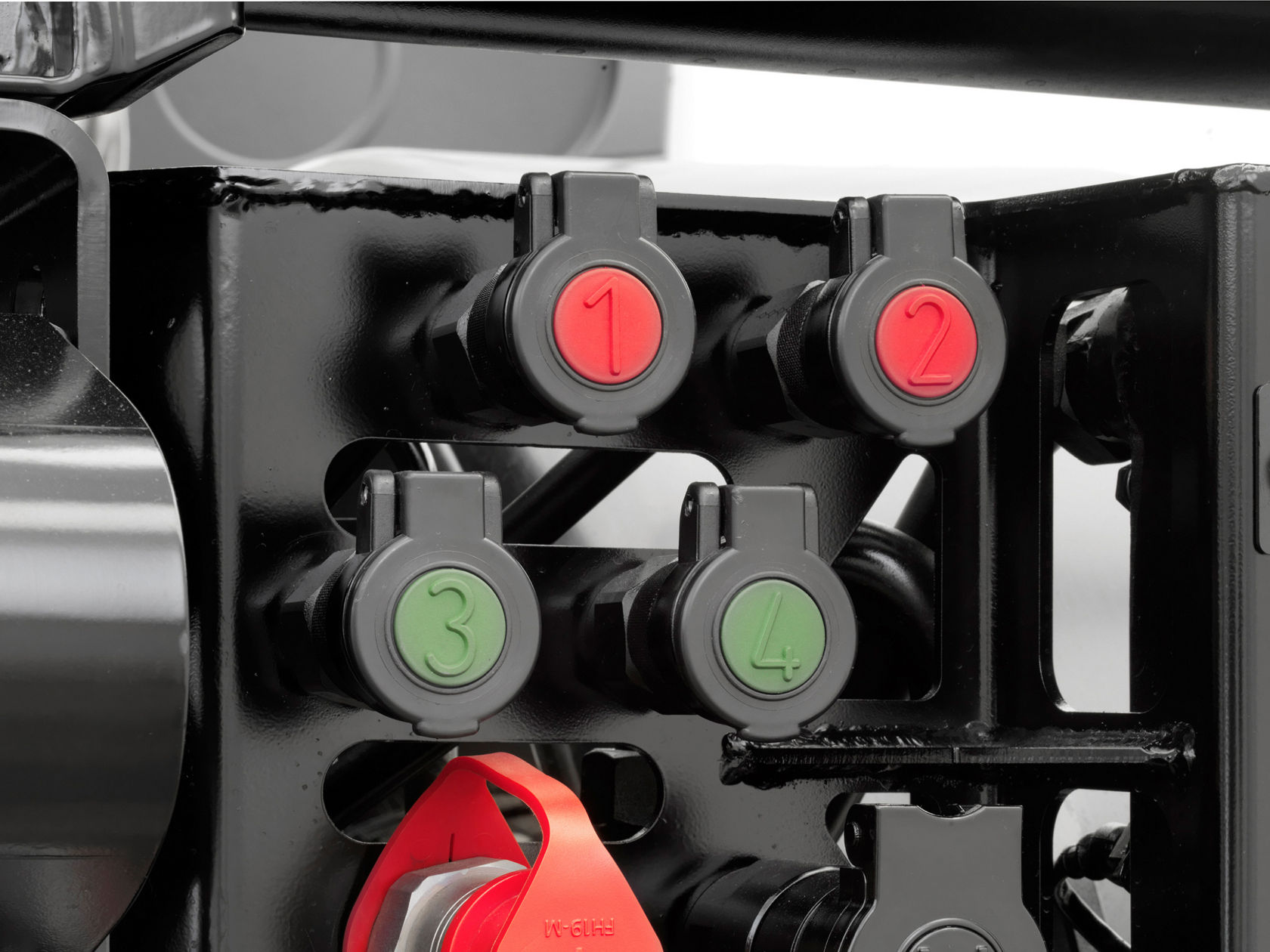 Close-up of a row of four numbered connectors on a black metal frame. Connectors 1 and 2 are red, while 3 and 4 are green.